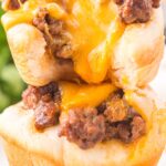 Two muffin cup cheeseburgers stacked on top of each other.