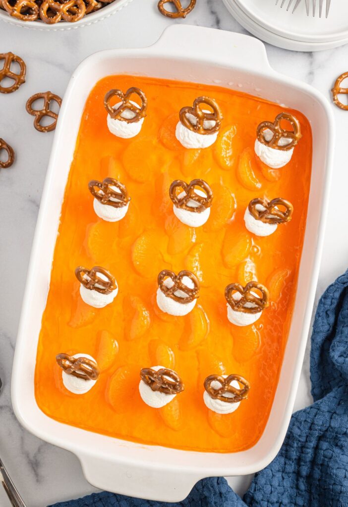 Overhead picture of a pan of orange layer with pretzels on it. 