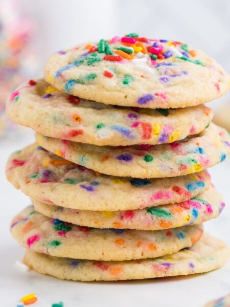 Stack of cookies with colored sprinkles around it.