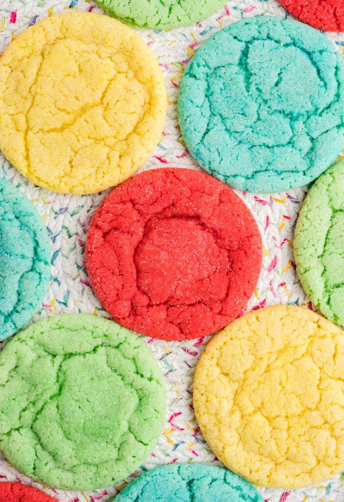 Overhead shot of colored cookies on a confetti placemat. 