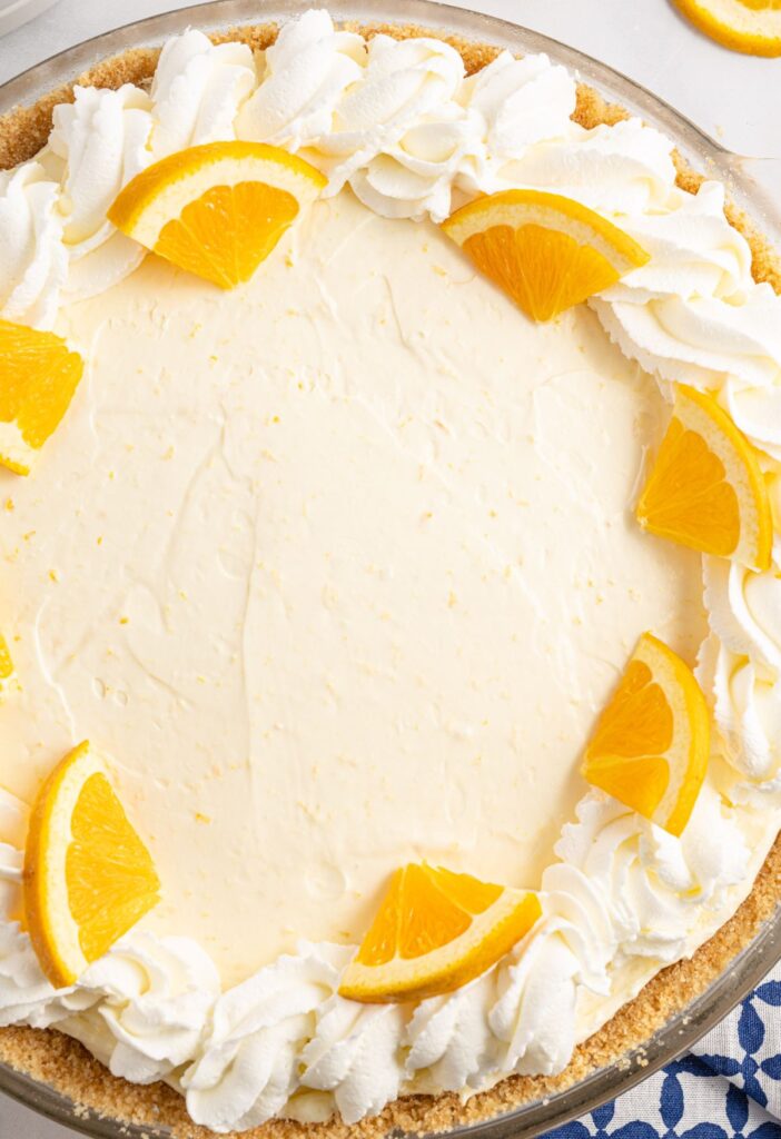 Overhead shot of a pie with orange slices on top. 