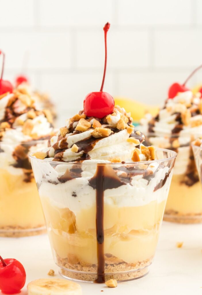 A dessert cup with layers of banana split. 
