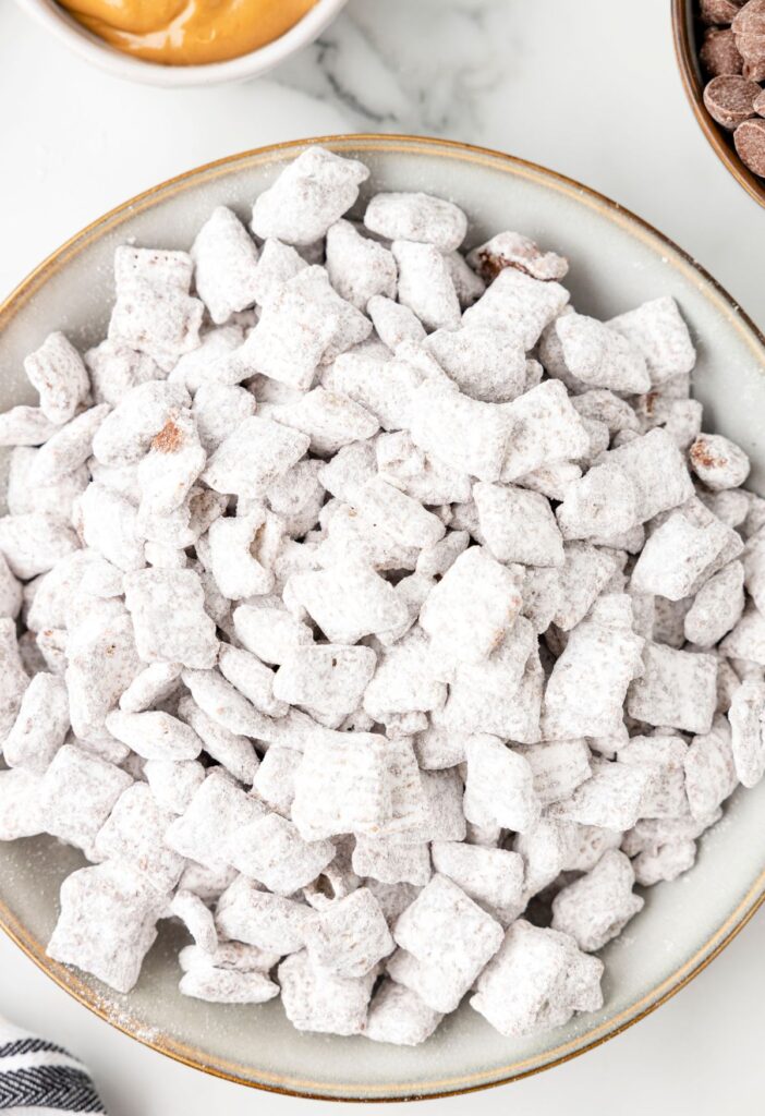 Bowl of the snack mix with chex cereal and powdered sugar. 