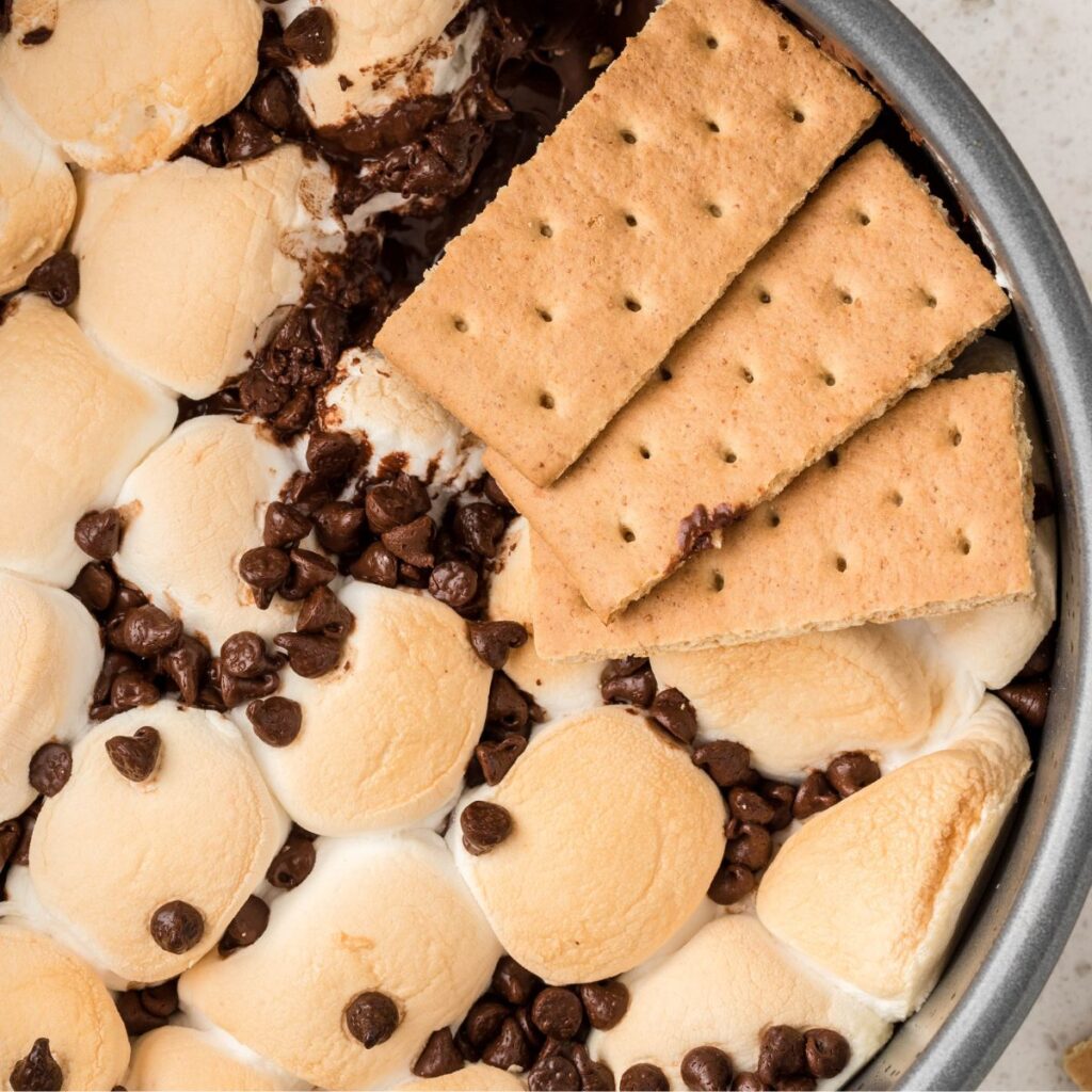 a sweet dip with crackers on top of the toasted marshmallows