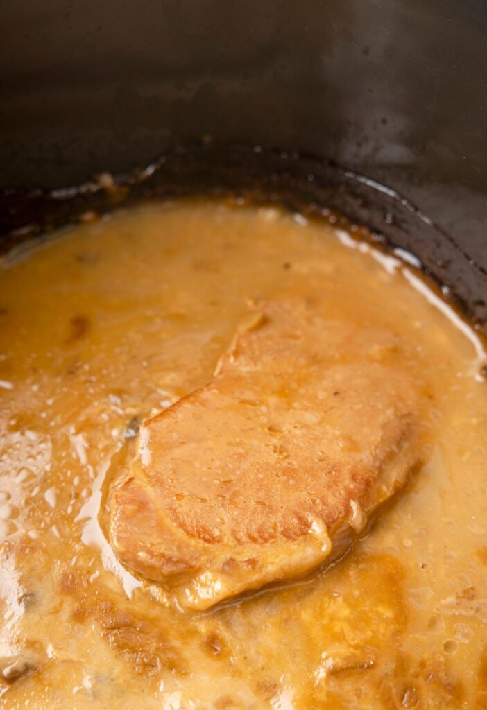 Pork chops smothered in gravy inside the crockpot. 