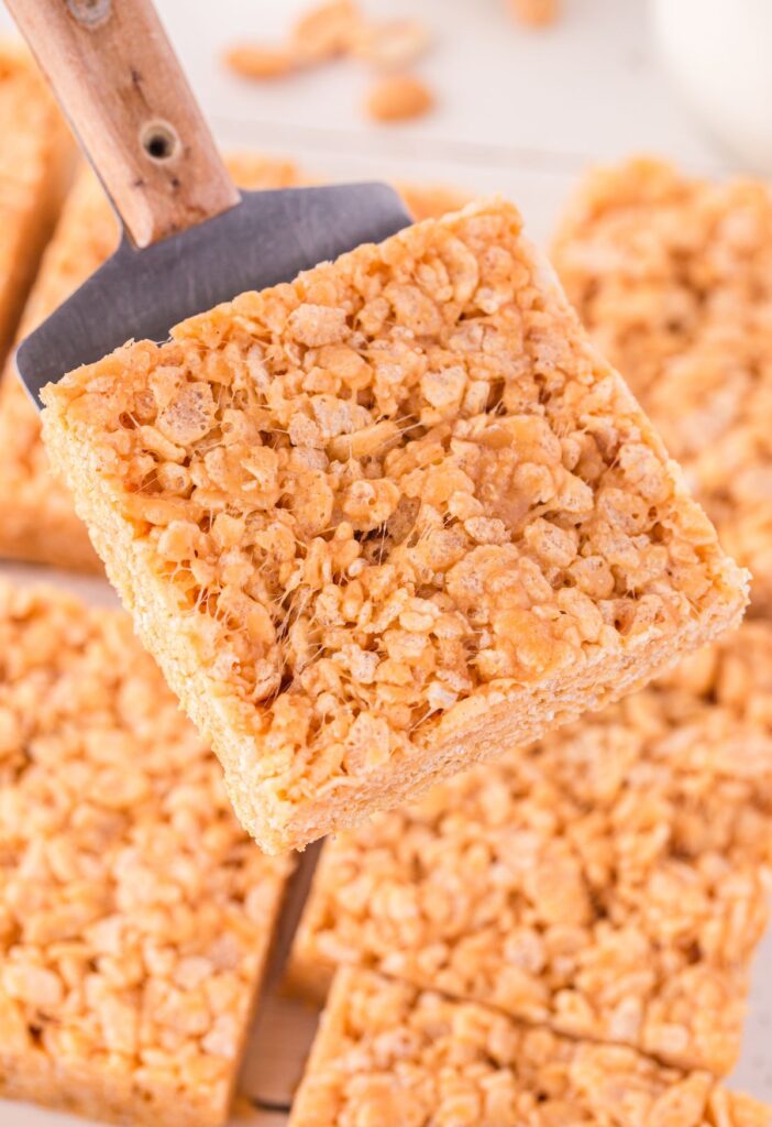 A serving spatula with a krispie treat on it.