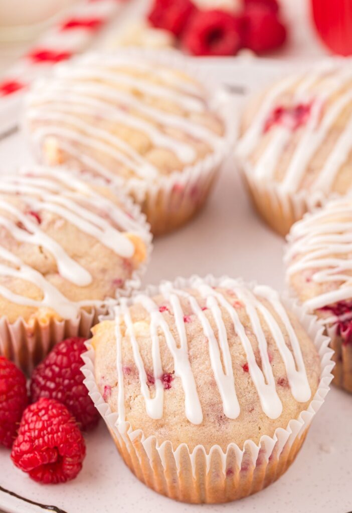 Glazed muffins on a white plate with raspberries