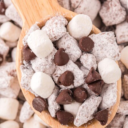 A wooden spoon with some muddy buddies in it, showing it up close in the picture.