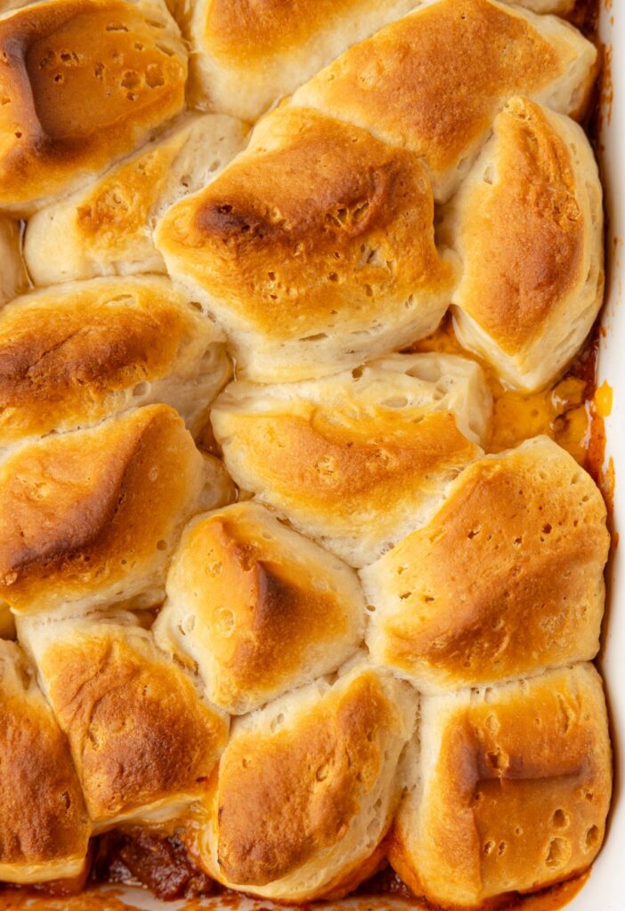 The top of the biscuit casserole with golden brown biscuits on it.